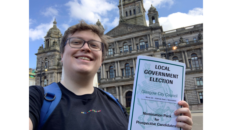 Blair smiling holding his local government election certificate