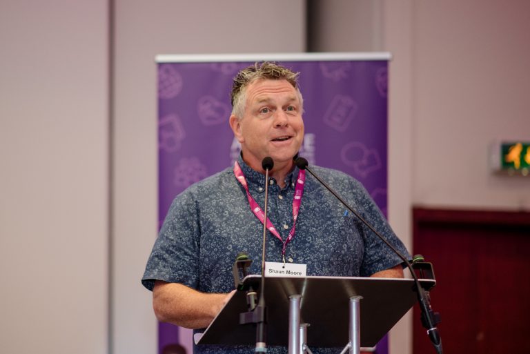 Photo of poet Shaun Moore behind a lecturn