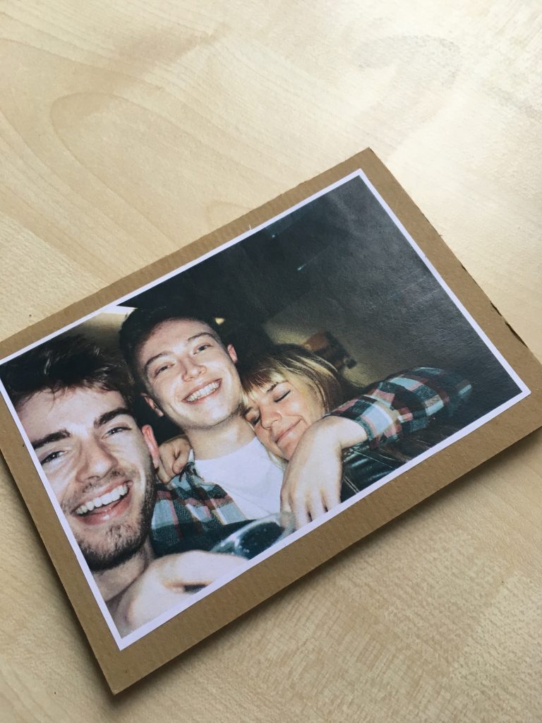 A picture of three young people smiling at the camera