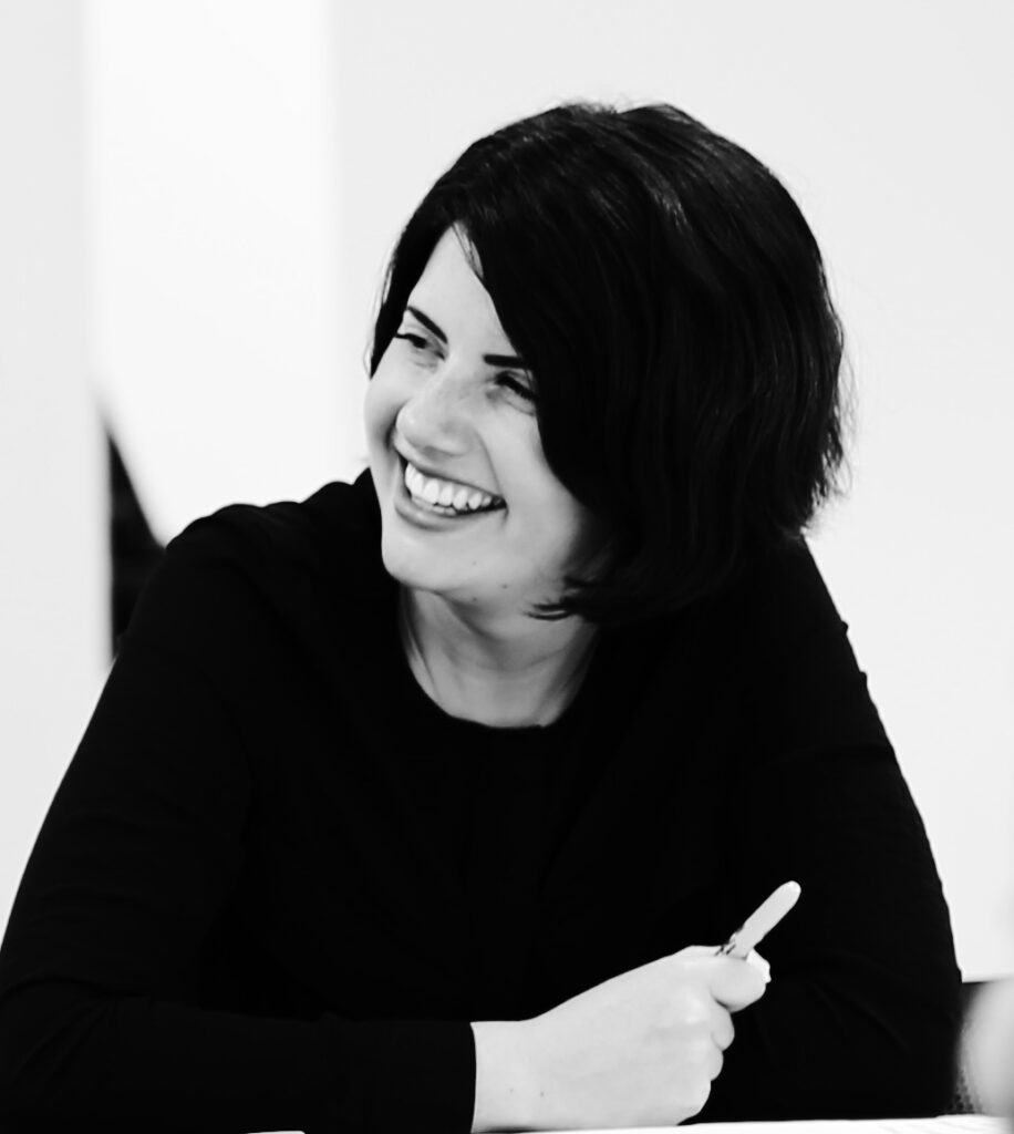 Tara smiling and looking to the left, the photo is black and white