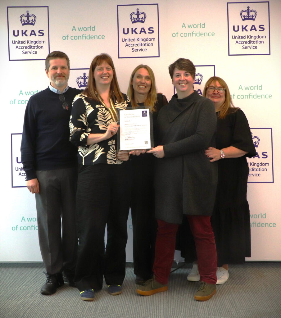 Photograph shows NHS Tayside audiology team receiving their UKAS certificate of accreditation for IQIPS audiology